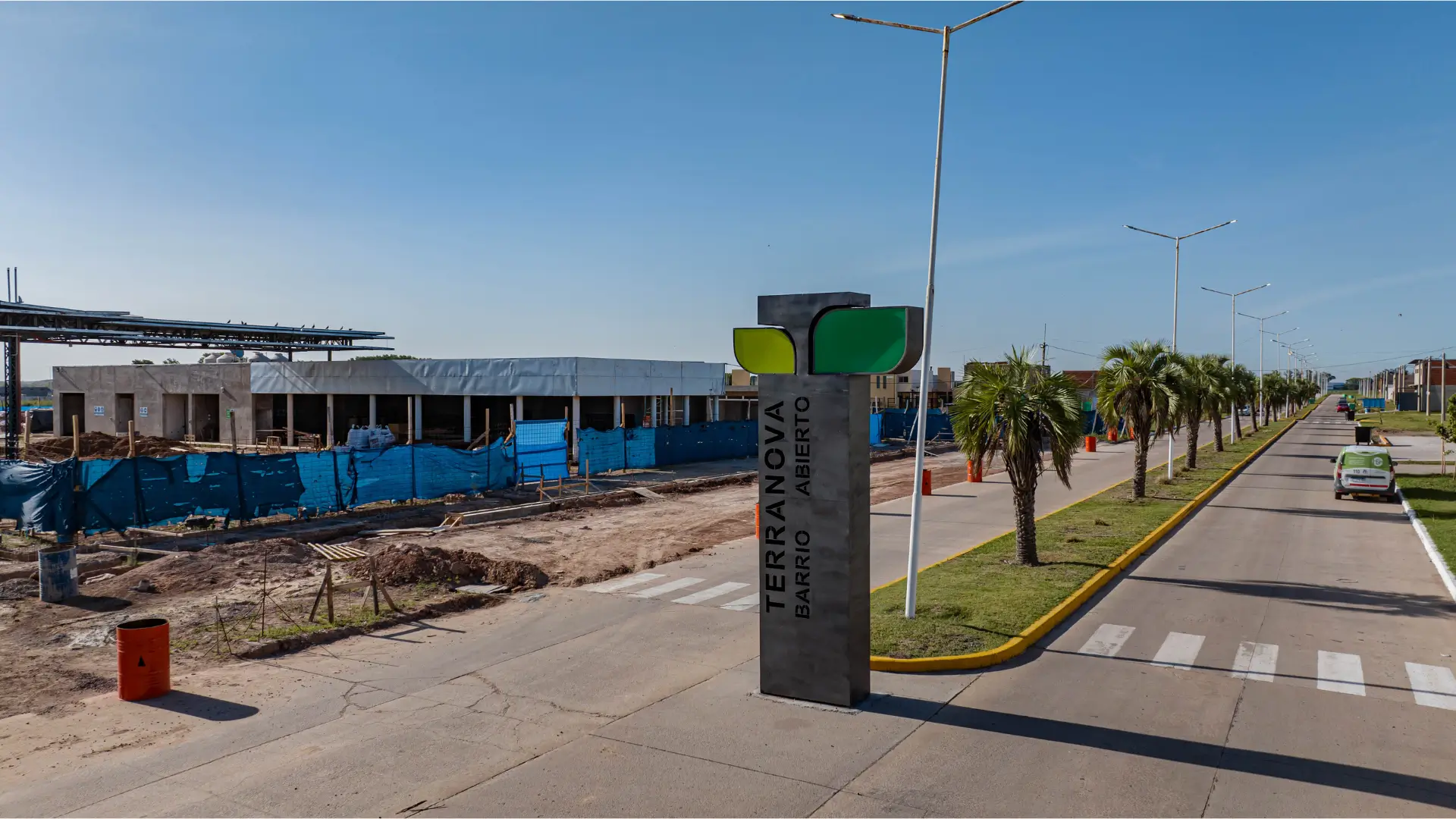 Acceso al barrio abierto Terranova con avenida arbolada de palmeras